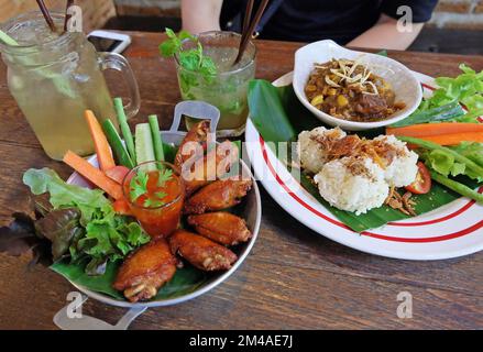 Riso appiccicoso fritto servito con curry della Thailandia settentrionale, ali di pollo e calamari fritti in pastella Foto Stock