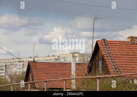 Il tetto di una vecchia casa di un piano fatta di ardesia rossa contro il cielo in Ucraina Foto Stock