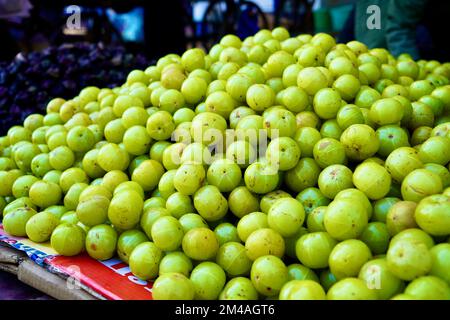 Uva spina indiana che vende sul mercato, uva spina indiana gustosa e sana chiamata AMLA in lingua hindi dell'india, uva spina indiana nel mercato per sal Foto Stock