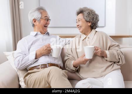 Allegro coppia cinese anziana bere caffè a casa Foto Stock