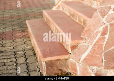 Architettura ampia scala esterna rosa fatta di pavimenti in granito nel cortile anteriore. Ampia scala in cemento. Foto Stock