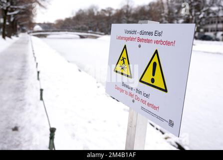 Monaco, Germania. 20th Dec, 2022. Un segno con l'iscrizione 'attenzione - ghiaccio sottile! Pericolo di vita! Non entrare!' Si può vedere al canale di Nymphenburg. Credit: Sven Hoppe/dpa/Alamy Live News Foto Stock