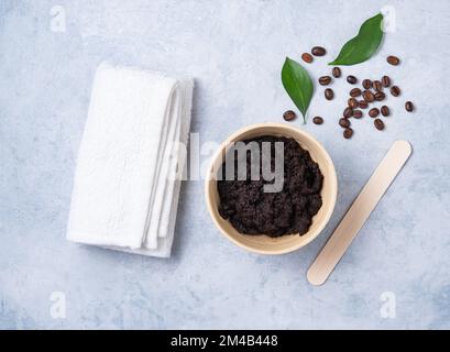 Concetto con ingredienti naturali per la pulizia del caffè a casa con chicchi di caffè e asciugamano bianco su sfondo blu. Cura della pelle del corpo. Vista dall'alto e copia Foto Stock