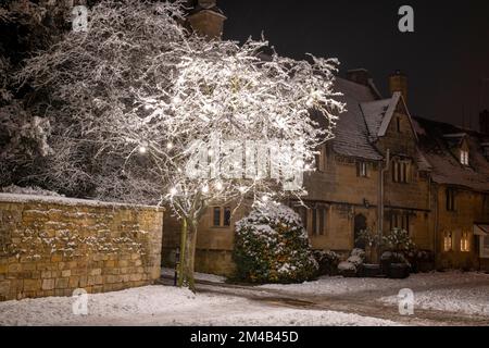 Il villaggio di Broadway e le decorazioni dell'albero di Natale di notte nella neve. Broadway, Cotswolds, Worcestershire, Inghilterra Foto Stock