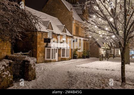 Il villaggio di Broadway e le decorazioni dell'albero di Natale di notte nella neve. Broadway, Cotswolds, Worcestershire, Inghilterra Foto Stock