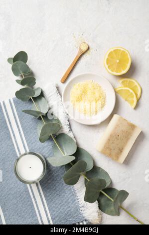 Sale marino giallo biologico con limone, sapone e ramificazione di eucalipto su sfondo bianco. Il concetto di spa e benessere. Vista dall'alto e copia Foto Stock