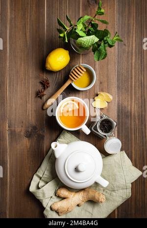 Sistema immunitario booster - piatto tè con zenzero, miele, limone, menta e spezie su uno sfondo di legno scuro. Il concetto di cibo sano. Vista dall'alto. Foto Stock