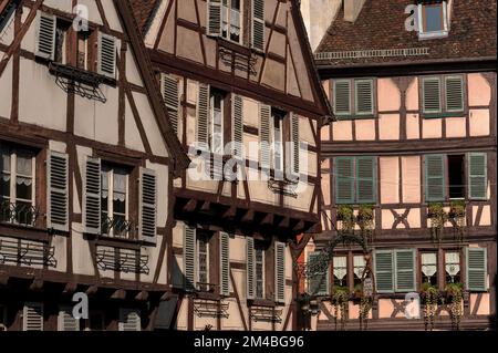 Antiche case a graticcio nella Grand’Rue e Rue des Marchands nel cuore storico di Colmar, Alsazia, Grand Est, Francia, con caratteristiche tipiche alsaziane come jetties o strapiombi, un tetto in ciottoli e, sulla facciata rosa, opere in legno scolpite in stile Fachwerk tedesco. Foto Stock