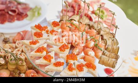 caviale rosso e involtini di salmone con formaggio di ricotta sul tavolo delle vacanze Foto Stock