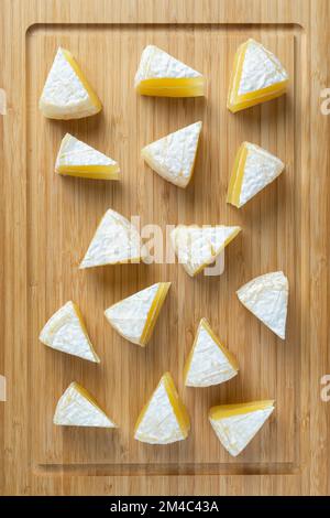 camembert tagliato a fette su un asse di legno Foto Stock