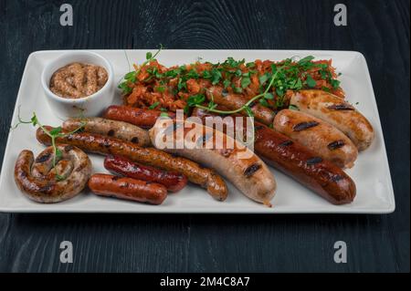 Salsiccia alla griglia con aggiunta di erbe e salsa di rafano sul piatto. Grigliate, barbecue, barbecue Foto Stock