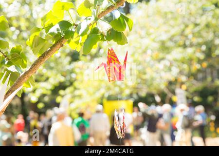 La gente si riunisce vicino al ciliegio piantato in memoria delle vittime di Hiroshima durante un evento commemorativo nel centro di Londra. Foto Stock