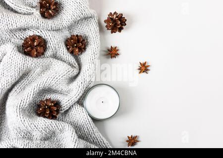 Inverno composizione intima di maglioni a maglia, candele, coni di pino, stelle di anice stellato. Foto Stock