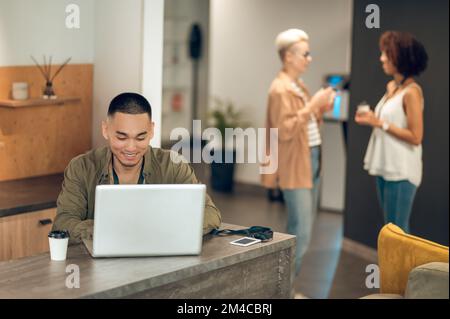 Lavoratore aziendale impegnato e i suoi colleghi nell'ufficio aziendale Foto Stock