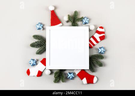 Composizione creativa di Natale con una cornice bianca per il testo e le congratulazioni per il nuovo anno e Natale. Calze rosse a maglia, cappello Babbo Natale, CHRI Foto Stock