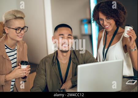 Allegro team di colleghi multinazionali che comunicano durante la pausa caffè Foto Stock