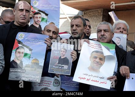 Gaza, Palestina. 20th Dec, 2022. I manifestanti tengono poster con le foto del prigioniero palestinese morto Nasser Abu Hamed durante una manifestazione di fronte alla sede del Comitato Internazionale della Croce Rossa a Gaza City. I palestinesi protestano contro la negligenza medica di Nasser Abu Hamid, morto di cancro all'interno di una prigione israeliana. Credit: SOPA Images Limited/Alamy Live News Foto Stock