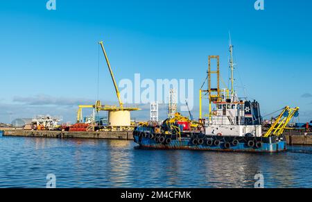 La nave di servizio Forth Sentinel che draga Leith Harbour con gru industriale sul molo, Edimburgo, Scozia, Regno Unito Foto Stock