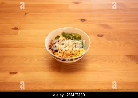 Una meravigliosa ciotola di insalata vegana con germogli di fagioli, anacardi, mais e spinaci Foto Stock