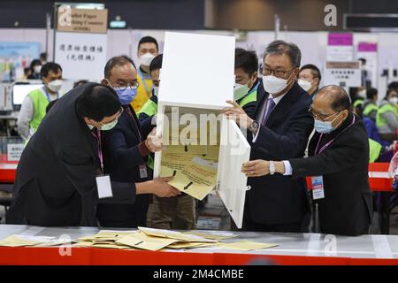 Sig. Justice Lok Kai-hong (3rd a sinistra) il segretario per gli affari costituzionali e continentali, sig. Erick Tsang Kwok-wai (secondo a sinistra); Il sig. Arthur Luk Yee-shun (1st da destra), SC, e il professor Daniel Shek hanno svuotato una cassa di voto nella zona di conteggio della stazione centrale di conteggio per le elezioni LegCo, al Centro Convegni ed Esposizioni di Hong Kong (HKCEC), WAN Chai. 18DEC22 SCMP /K. Y. Cheng Foto Stock