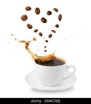 Tazza con piattino con un po' di caffè. Chicchi di caffè a forma di cuore. Bere concetto di amore. Isolato Foto Stock