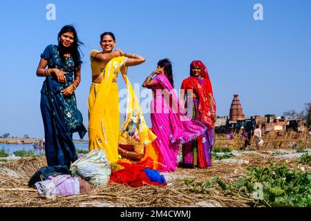 Donne modifica sari dopo un bagno nel fiume Yamuna Foto Stock