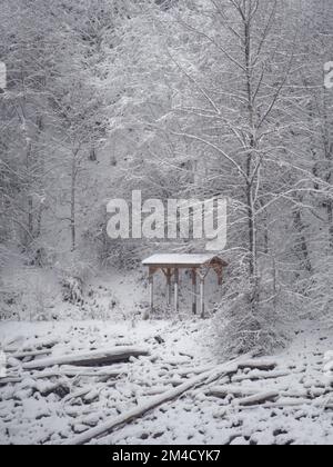 Un rifugio in legno immerso in un paesaggio invernale innevato sulla riva del lago Capilano presso il Parco Regionale del Fiume Capilano a North Vancouver, British col Foto Stock