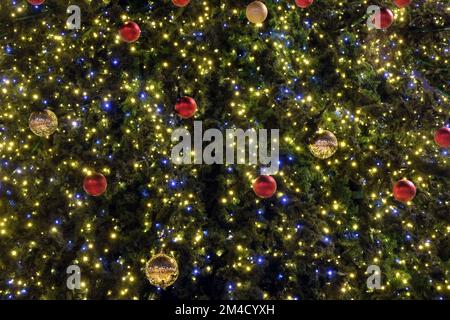 Alberi di Natale come sfondo nuovo anno con molte palline di natale colorate e illuminazione vista frontale primo piano Foto Stock