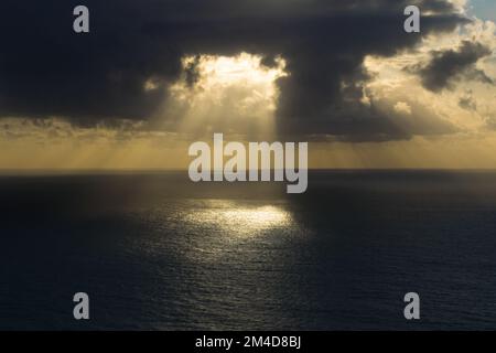 Spettacolare tramonto sul mare con la luce del sole che filtra attraverso le nubi Foto Stock