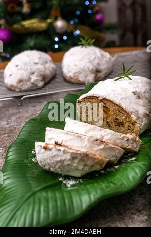 Natale stollen con zucchero a velo in un piatto verde Foto Stock