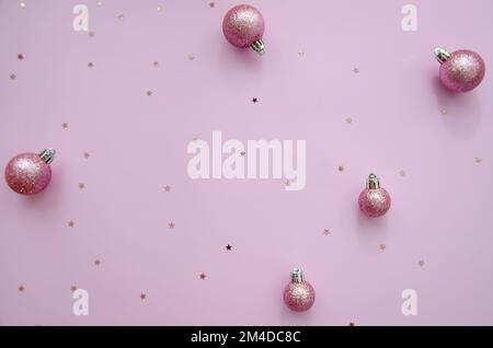 Composizione di Natale. Un motivo di palle di natale e stelle glitter su fondo rosa profondo. Appartamento, vista dall'alto, arredamento di Capodanno. Foto Stock