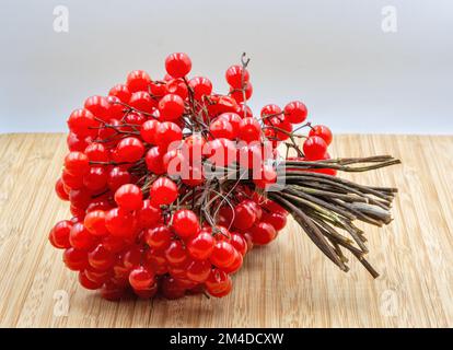 Riburnum rosso bacche closeup su sfondo di legno Foto Stock