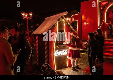 Zagabria, Croazia - 8 dicembre 2022: Festa di beneficenza dell'Avvento di Natale Coca-Cola. Gli elfi di Babbo Natale consegnano bottiglie di soda festive ai cittadini. Luminoso Foto Stock