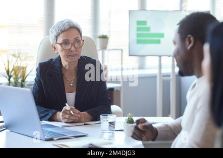Ritratto della donna matura capo riunione con i colleghi in ufficio, copia spazio Foto Stock