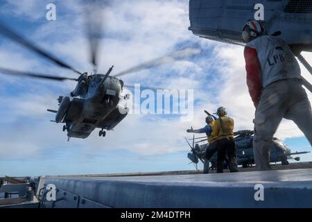 Oceano PACIFICO (12 dicembre 2022) i marinai a bordo di una nave portuale di trasporto anfibio USS John P. Murtha (LPD 26) effettuano operazioni di volo con un elicottero CH-53 Super Stallion assegnato a Marine Medium Tiltrotor Squadron (VMM) 362 (Rein.) Sul ponte di volo, 12 dicembre 2022. Murtha è progettato per fornire una forza anfibia integrata in grado di supportare comandanti operativi in tutto il mondo con capacità sia di attacco che anfibie. Il Makin Island Amphibious Ready Group, che comprendeva la nave d'assalto anfibio USS Makin Island (LPD 8) e le banchine di trasporto anfibie USS Anchorage (LPD 23) e US Foto Stock