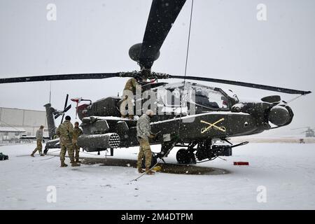 Soldati da 5th Squadrone, 17th reggimento di cavalleria, 2nd Brigata di Aviazione di combattimento, 2nd Divisione di Fanteria/ROK-US Divisione combinata spostare un elicottero AH-64E Apache in un hangar momenti dopo una tempesta di neve passata attraverso USAG Humphreys il 6 dicembre 2022. Indipendentemente dalle condizioni meteorologiche, i soldati continuano a eseguire la manutenzione programmata delle attrezzature dell'esercito per garantire che l'unità sia pronta a difendere la penisola coreana in un momento. (STATI UNITI Foto dell'esercito di Capt. Frank Spatt) Foto Stock