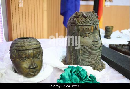 Abuja, Nigeria. 20th Dec, 2022. La testa del trofeo (l) e la testa commemorativa di un re sono tra gli oggetti di Berlino che giacciono su un tavolo del Ministero degli Esteri di Abuja, la capitale della Nigeria. Per la prima volta, la Germania sta restituendo questi e altri 19 bronzi del Benin dall'epoca coloniale alla Nigeria. Credit: Annette Riedl/dpa/Alamy Live News Foto Stock