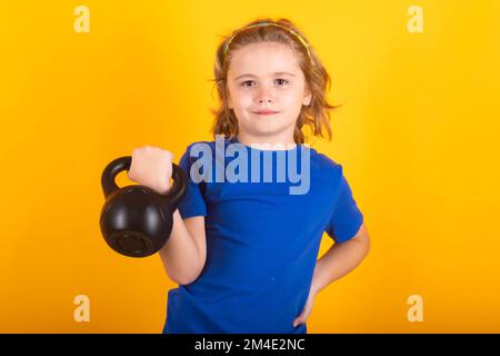 Carino bambino ragazzo pompare i muscoli del braccio con il manubro Kettlebell. Fitness bambini con manubri. Foto Stock