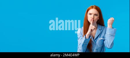 Shut up o altro. Arrabbiato e dispiaciuto redhead girl minacciano compagno di stanza di essere tranquillo e il pugno di scuotimento, avvertimento comportarsi bene, non dite a nessuno segreto, fare Foto Stock