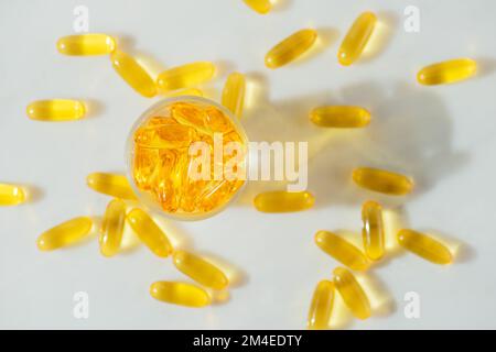 Omega-3 capsule di olio di pesce in una bottiglia di vetro su sfondo marmo bianco alimentazione sana, integratore alimentare medico, vitamine D, primo piano Foto Stock