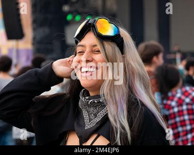 Medellin, Antioquia, Colombia - Novembre 14 2022: Giovane donna colombiana che cede indossando occhiali colorati a forma di cuore Foto Stock