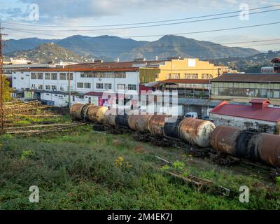 Batumi, Georgia. 12.06.2022 vecchi carri cisterna arrugginiti. Treno merci sullo sfondo della città. Zona industriale della città meridionale. Georgia Foto Stock
