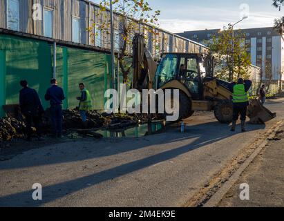 Batumi, Georgia. 11.28.2022 trattore su strada. Scavo. Riparazione delle comunicazioni. Macchina di lavoro con benna Foto Stock