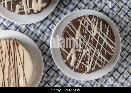 Vista dall'alto degli alfajores al cioccolato, caramelle tipiche dell'Argentina, su una tovaglia a scacchi. Foto Stock