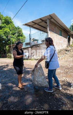 La Labor, la Libertad, Salvador - 27 ottobre 2022 - le donne Salvadoran raccolgono la spazzatura in una grande borsa in campagna Foto Stock