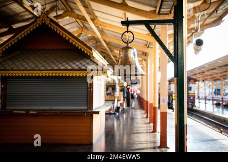 La campana dorata della piattaforma e' vista durante l'ora d'oro alla Stazione ferroviaria di Chiang mai. Lo Special Express 14, una popolare linea turistica parte della flotta della ferrovia statale della Thailandia (SRT), effettua il suo viaggio notturno da Chaing mai (CNX) a Bangkok (BKK). Foto Stock