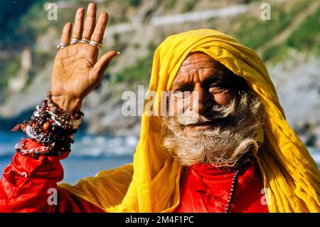 Sadhu, uomo santo, sventolando a Devprayag, la confluenza dei fiumi santi Baghirati e Alakananda. Devprayag , India Foto Stock