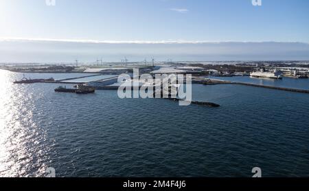 Fehmarn, Germania. 16th Dec, 2022. Accanto al porto di lavoro e al porto dei traghetti di Puttgarden (fotografia aerea scattata con un drone) si trova la fossa di scavo (M) per il portale del tunnel al tunnel di Fehmarnbelt. Il tunnel ferroviario e stradale di 18 km collegherà l'isola di Fehmarn e l'isola danese di Lolland dal 2029. Secondo Femern A/S, il costo è di 7,1 miliardi di euro. Credit: Christian Charisius/dpa/Alamy Live News Foto Stock