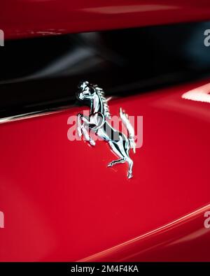 Un distintivo di cavallo Ferrari di un SF-90 stradale su una cromatura rossa lucida Foto Stock