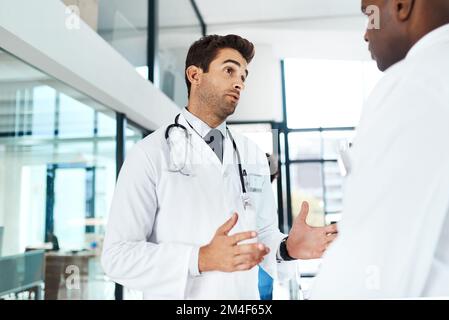 Insieme per un'assistenza di qualità al paziente. due medici che hanno una discussione in un ospedale. Foto Stock